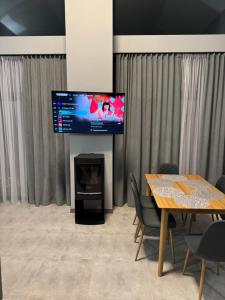 a living room with a table and a flat screen tv at cottages GRUN in Yablunytsya