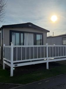 een huis met een wit hek en een veranda bij Bishops Beach Stays in Walton-on-the-Naze