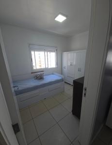 a bedroom with a blue bed and a window at Dona Iva in Capão da Canoa
