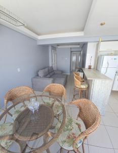 a living room with a table and chairs and a couch at Dona Iva in Capão da Canoa +4 photos