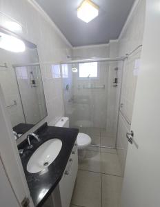 een badkamer met wastafel, douche en toilet bij Dona Iva in Capão da Canoa