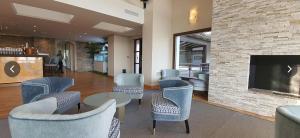 una hall con sedie, tavoli e un camino di Penthouse Karina Los Arqueros a Benahavís