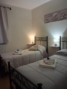 una camera da letto con due letti con asciugamani e bevande sopra di Il Doganiere a Montecchio