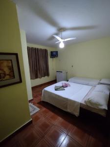 een slaapkamer met een bed en een plafondventilator bij Pousada do Nilo in Itapemirim