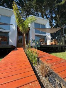 una casa con una passerella rossa davanti di Complejo Raíces a Mar de Cobo