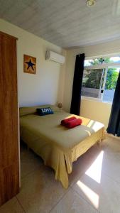 a bedroom with a bed in a room with a window at AK Lodge Raiatea in Raiatea