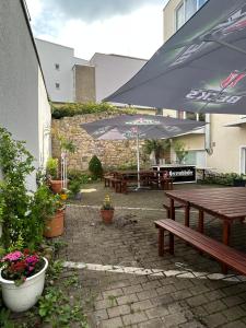 a patio with benches and tables with umbrellas at City Lux Hannover in Hannover
