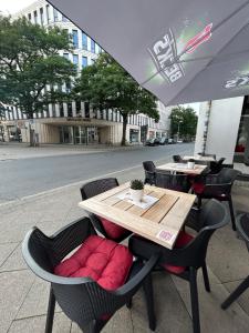 a table and chairs with a table and an umbrella at City Lux Hannover in Hannover