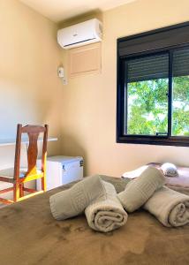 een slaapkamer met een bed met een handdoek erop bij Pousada Pedra Bonita in Cristal