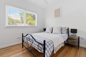 a bed in a white bedroom with a window at The Ocean Gem at Rosebud with its own Private Beach Box in Rosebud