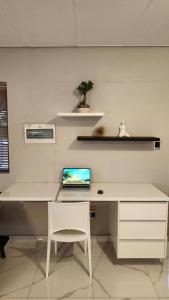 a white desk with a laptop computer on top of it at Pine Self-Catering Unit in Windhoek