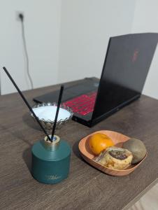 een tafel met een bord eten en een laptop bij Home Sweet in Balaovit