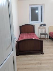 een bed in een kamer met een raam en een stoel bij Home Sweet in Balaovit