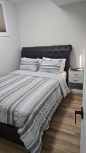 a white bed with a black headboard in a bedroom at Elian's Nest in Saskatoon