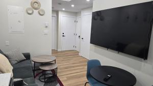 a living room with a large flat screen tv on a wall at Elian's Nest in Saskatoon