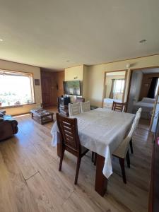 a dining room with a white table and chairs at Casa con acceso directo al lago y hermosas vistas in Puerto Varas +13 photos