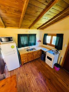 a small kitchen with a refrigerator and a stove at Cabaña 4 in Necochea