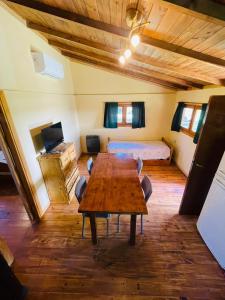 a room with a wooden table and a bed at Cabaña 4 in Necochea