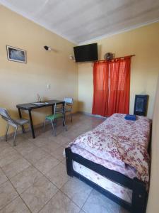 a bedroom with a bed and a table and chairs at Deptos Peumayen Familiar - Parking - Excelente Ubicacion - Full Equipado in Río Colorado