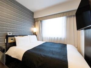 ein Hotelzimmer mit einem Bett und einem Fenster in der Unterkunft APA Hotel Kintetsu Nara Ekimae in Nara
