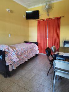 a bedroom with a bed and a desk and a table with a chair at Deptos Peumayen Familiar - Parking - Excelente Ubicacion - Full Equipado in Río Colorado +46 photos