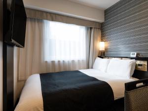 ein Hotelzimmer mit einem Bett und einem Fenster in der Unterkunft APA Hotel Kintetsu Nara Ekimae in Nara