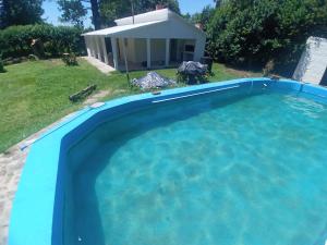 een groot zwembad in een tuin met een huis bij Quinta con pileta Las Acacias in Paraná