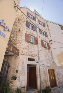 an old stone building with windows and a door at Paulla in Šibenik