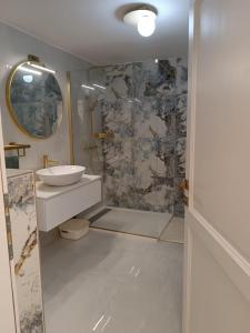 a bathroom with a sink and a shower with a mirror at Paulla in Šibenik