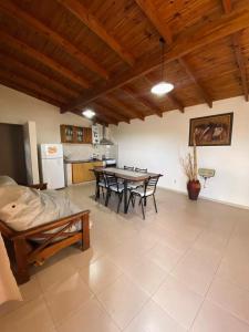 a living room with a table and chairs and a kitchen at Complejo de cabañas El Nido in Mina Clavero