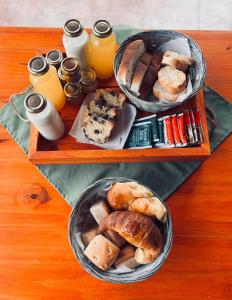 two trays filled with different types of bread and orange juice at Complejo de cabañas El Nido in Mina Clavero +4 photos