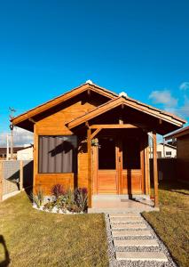 a cabin with a wooden door in a yard at Cabana Raiz & Mar - 01 in Imbituba