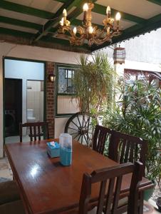 a dining room table with chairs and a chandelier at Paviliun Omah Ndanu in Yogyakarta