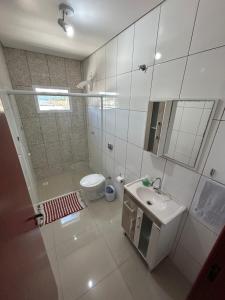 a bathroom with a shower and a toilet and a sink at Edificio Freitas in Imbituba +26 photos