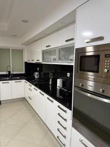 a kitchen with white cabinets and a microwave at Casa Cucuia in Praia +41 photos