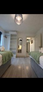 a bedroom with two beds and a hallway with a staircase at Shangri-La Large Family Townhouse free carpark in Killarney +12 photos