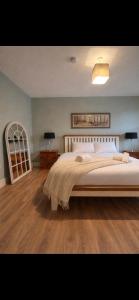 a bedroom with a large bed and a wooden floor at Shangri-La Large Family Townhouse free carpark in Killarney