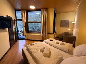 twee bedden in een kamer met een raam bij Boutique HOTEL am KRANICHSEE in Hahnenklee-Bockswiese