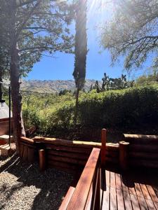 een houten bank met uitzicht op de bergen bij A Mi Manera Apart in Merlo