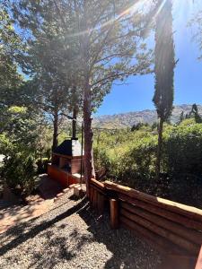 een houten hek met een boom en bergen op de achtergrond bij A Mi Manera Apart in Merlo +78 foto's