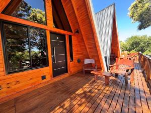 a front porch of a wooden house with a bench at A Mi Manera Apart in Merlo