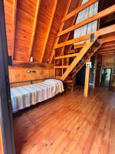 a bedroom with a bed in a wooden attic at A Mi Manera Apart in Merlo