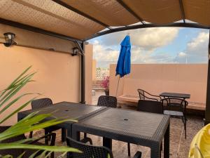 a patio with a table and a blue umbrella at Condo Riviera in Puerto Aventuras