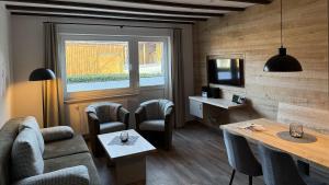 a living room with a couch and chairs and a tv at Hardthof-Sauerland in Schmallenberg