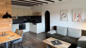 a kitchen and a living room with a couch and a table at Hardthof-Sauerland in Schmallenberg