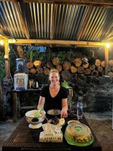 a woman standing behind a table with food at SIRUS Resort Tagulandang in Kisihang