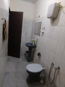a bathroom with a toilet and a sink at Recanto Dunas Santa Rita in Estância