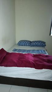 a bed with purple and white sheets and a pillow at Recanto Dunas Santa Rita in Estância