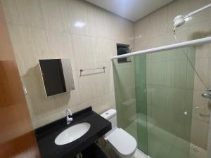 a bathroom with a sink and a glass shower at Ap Seabra 2 quartos in Seabra