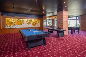 twee pooltafels in een kamer met een schilderij bij Higaki Hotel in Gamagori